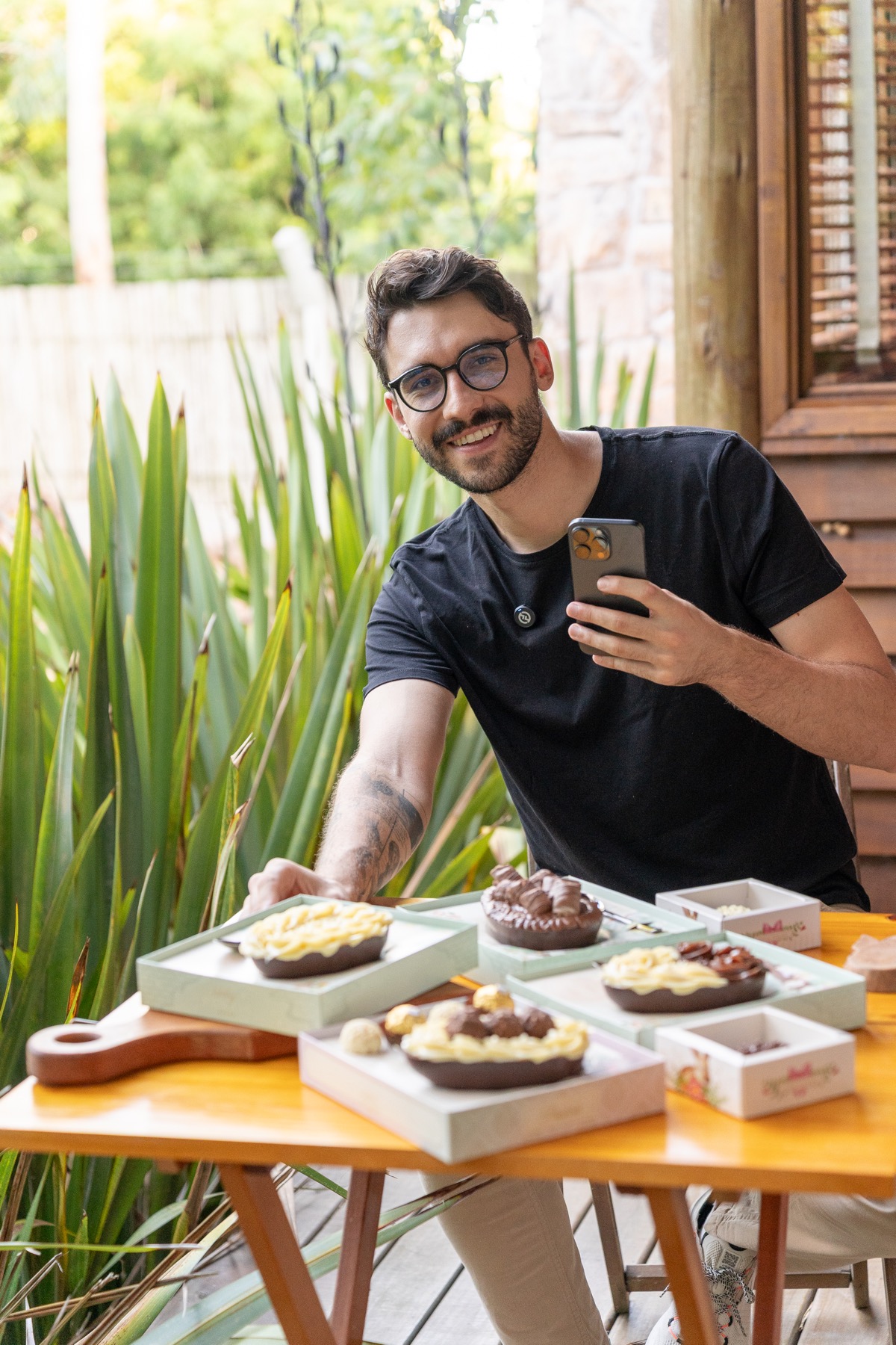 Nathan Abritta, criador do Beleza do Prato, fotografando produtos de confeitaria